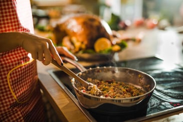 Close up of a woman preparing rice with vegetables for Thanksgiving dinner in the kitchen