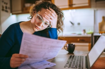A frustrated woman looks at banking paperwork