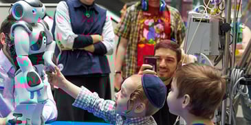 A young boy reaches out to touch the NAO robot at Children's Hospital of Philadelphia
