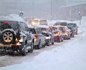 A line of cars in traffic in the snow