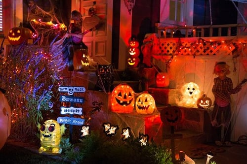 a neighborhood home is decorating with Halloween Lights and pumpkins