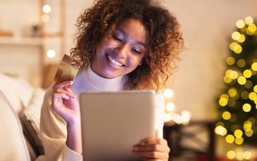 A woman shops on her tablet using her credit card