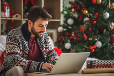 man on his laptop being aware of scams this holiday season