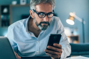 man on phone trying to detect a phishing scam