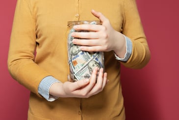 a jar filled with one hundred dollar bills for retirement