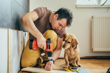 man-working-on-home-improvement-projects-with-dog