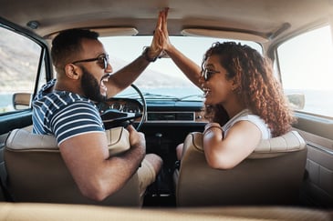 Man and Woman High fiving in a car