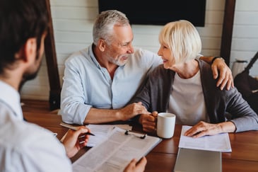 A mature couple discuss finances with a professional