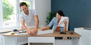 Couple assembling a cabinet in apartment