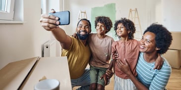 A young family taking a family photo in a room they are renovating