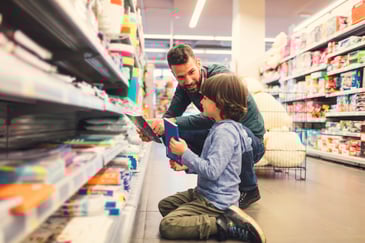 A man and his son browse an aisle of school supplies