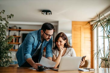 A husband and wife on a laptop working on their finances