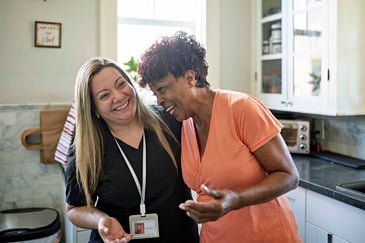 two women laughing in the kitchen