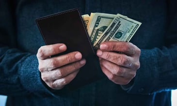 close up of hands taking money out of a wallet
