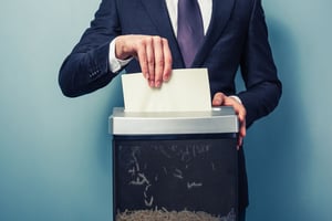 A man shreds documents in a home shredder
