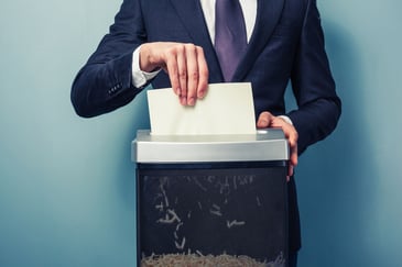 A man shreds documents in a home shredder