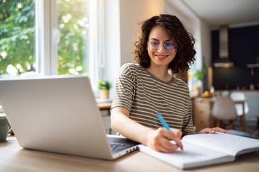Young woman with glasses on computer and financially budgeting 