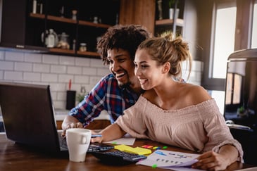 A young couple look at their finances together in the kitchen