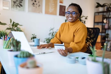 A young woman uses her laptop and credit card