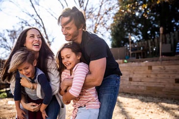 A family outside in a hay field