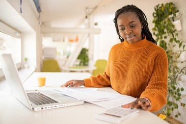woman paying bills in front of a laptop