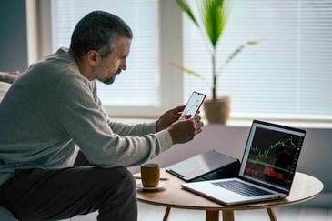 a middle aged man researching stocks on his laptop