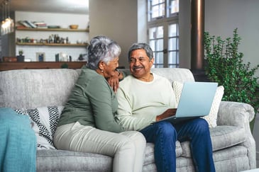couple-sitting-on-couch-with-laptop