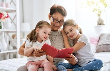 A grandmother reads to her two granddaughters