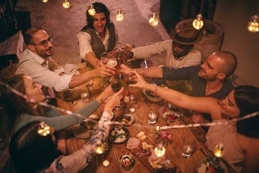A group of friends toast over food and drink