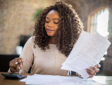 A woman uses a calculator to plan her finances