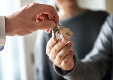 a new home buyer being handed house keys